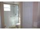 Bathroom features a glass-enclosed shower, white tile and fixtures for a clean and modern design at 537 Coral Trace Blvd, Edgewater, FL 32132