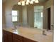 Bathroom featuring dual sinks, large mirror, and a glass-enclosed shower at 537 Coral Trace Blvd, Edgewater, FL 32132