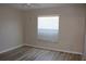 Cozy bedroom with wood-look flooring, a ceiling fan, and a bright window with blinds at 537 Coral Trace Blvd, Edgewater, FL 32132