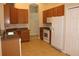 Kitchen featuring wood cabinets, tile flooring, and white appliances at 537 Coral Trace Blvd, Edgewater, FL 32132