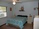 Serene bedroom with a teal and white comforter and ceiling fan at 2325 Date Palm Dr, Edgewater, FL 32141