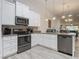 Well-lit kitchen features white cabinets, stainless steel appliances, granite countertops, and a decorative backsplash at 3331 Torre Blvd, New Smyrna Beach, FL 32168