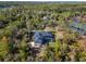 Aerial view of house with pool and screened enclosure, surrounded by lush green landscape at 335 Woodridge Dr, Geneva, FL 32732