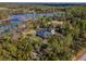 Aerial view of a house with a pool, situated on a wooded property near a lake at 335 Woodridge Dr, Geneva, FL 32732