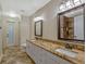 Elegant bathroom boasts double vanity with granite countertop and large mirror at 335 Woodridge Dr, Geneva, FL 32732