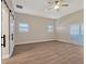 Spacious bedroom with wood-look flooring and barn door at 335 Woodridge Dr, Geneva, FL 32732