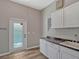 Functional laundry room with white cabinets, granite countertop, and exterior access at 335 Woodridge Dr, Geneva, FL 32732