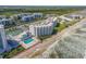 Aerial view of beachfront community, tennis courts, and pool at 5203 S Atlantic Ave # 814B, New Smyrna Beach, FL 32169