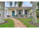 Charming yellow house with teal door, porch, and landscaped yard at 915 Maple St, New Smyrna Beach, FL 32169