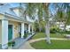 Quaint yellow house with teal door, porch, and tropical landscaping at 915 Maple St, New Smyrna Beach, FL 32169