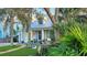 Charming yellow house with gray metal roof, front porch, and lush landscaping at 915 Maple St, New Smyrna Beach, FL 32169