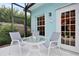 Enjoy relaxing on this screened porch, featuring a glass-top table and chairs at 915 Maple St, New Smyrna Beach, FL 32169