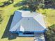 Single-story home with metal roof, viewed from above, showcasing its layout and yard at 977 Bay Dr, New Smyrna Beach, FL 32168