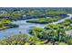 Aerial view of waterfront property with lush landscaping and private dock at 977 Bay Dr, New Smyrna Beach, FL 32168