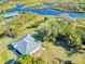 Single-story home with metal roof, and waterfront lot, aerial view at 977 Bay Dr, New Smyrna Beach, FL 32168