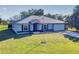 Single-story home with metal roof, attached garage, and a spacious lawn at 977 Bay Dr, New Smyrna Beach, FL 32168