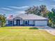 Single-story home with metal roof, attached garage, and landscaped lawn at 977 Bay Dr, New Smyrna Beach, FL 32168