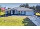 Single-story home with metal roof, attached garage, and a spacious lawn at 977 Bay Dr, New Smyrna Beach, FL 32168