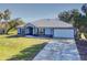 Single-story home with metal roof, attached garage, and a spacious lawn at 977 Bay Dr, New Smyrna Beach, FL 32168