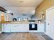 White kitchen with stainless steel appliances and view into living room at 977 Bay Dr, New Smyrna Beach, FL 32168