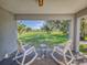 Covered patio with rocking chairs offering scenic backyard views at 977 Bay Dr, New Smyrna Beach, FL 32168