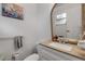 Well-lit bathroom with a woven mirror, neutral color scheme, and modern fixtures at 1052 Tompkins Dr, Port Orange, FL 32129