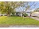 Charming single-story home with lush lawn, mature trees, and well-maintained landscaping at 1052 Tompkins Dr, Port Orange, FL 32129