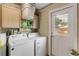 Laundry room with a washer, dryer, cabinets, and a door to the outside at 1052 Tompkins Dr, Port Orange, FL 32129