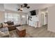 Bright living room with wood floors, white walls, large windows, and comfortable seating area at 1052 Tompkins Dr, Port Orange, FL 32129