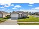 Exterior view of a house showcasing a two-car garage and a spacious front yard at 230 Oak Branch Dr, Edgewater, FL 32141