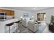 Open living space with kitchen bar, gray flooring, and access to a screened porch at 230 Oak Branch Dr, Edgewater, FL 32141