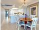 Bright kitchen and dining area with white cabinets, granite countertops, and a round wooden table at 4139 S Atlantic Ave # B608, New Smyrna Beach, FL 32169