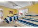 Bright bedroom featuring two twin beds with striped bedding and shuttered window at 4811 Saxon Dr # C102, New Smyrna Beach, FL 32169