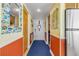 Hallway with coastal decor, adjacent stainless steel refrigerator, and white entry door at 4811 Saxon Dr # C102, New Smyrna Beach, FL 32169