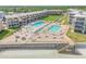 Aerial view of community with multiple pools, sun loungers, and beach access at 4811 Saxon Dr # C102, New Smyrna Beach, FL 32169