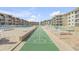 View of shuffleboard and pool area surrounded by beautiful condo buildings perfect for outdoor activities and relaxation at 4811 Saxon Dr # C102, New Smyrna Beach, FL 32169