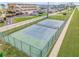 Aerial view of a well-maintained tennis court surrounded by green grass at 4811 Saxon Dr # C102, New Smyrna Beach, FL 32169