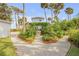 Landscaped backyard featuring lush greenery, trees, and a gravel pathway leading to the house at 4946 Halifax Dr, Port Orange, FL 32127