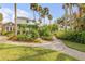 Landscaped backyard featuring lush greenery, trees, and a gravel pathway leading to the house at 4946 Halifax Dr, Port Orange, FL 32127