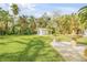 Expansive backyard featuring lush green grass, mature trees, and a charming fountain at 4946 Halifax Dr, Port Orange, FL 32127