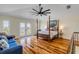 Bright bedroom featuring hardwood floors, a balcony, and a four poster bed at 4946 Halifax Dr, Port Orange, FL 32127