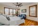 Bedroom with hardwood floors, large windows, two beds, and a decorative blue sofa at 4946 Halifax Dr, Port Orange, FL 32127