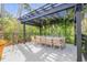 Outdoor patio features a pergola, dining table, and chairs surrounded by lush greenery at 4946 Halifax Dr, Port Orange, FL 32127
