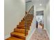 Wooden staircase with iron railings, connecting to the upstairs living area at 4946 Halifax Dr, Port Orange, FL 32127