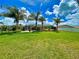 Large backyard with grassy area, palm trees, and screened pool at 6812 Stoneheath Ln, Port Orange, FL 32128