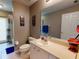 Clean bathroom with a toilet, sink, shower, and mirror at 6812 Stoneheath Ln, Port Orange, FL 32128