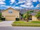 Tan house with a two-car garage and lush landscaping at 6812 Stoneheath Ln, Port Orange, FL 32128