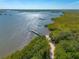 Stunning waterfront aerial view showcases a private dock and lush mangrove shoreline on a sunny day at 731 Laurel Bay Cir, New Smyrna Beach, FL 32169