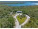 A high aerial view of a building nestled into the natural landscape next to a lake and mature trees at 731 Laurel Bay Cir, New Smyrna Beach, FL 32169