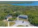 An aerial view features a building surrounded by a lush landscape, a lake, and a parking area at 731 Laurel Bay Cir, New Smyrna Beach, FL 32169